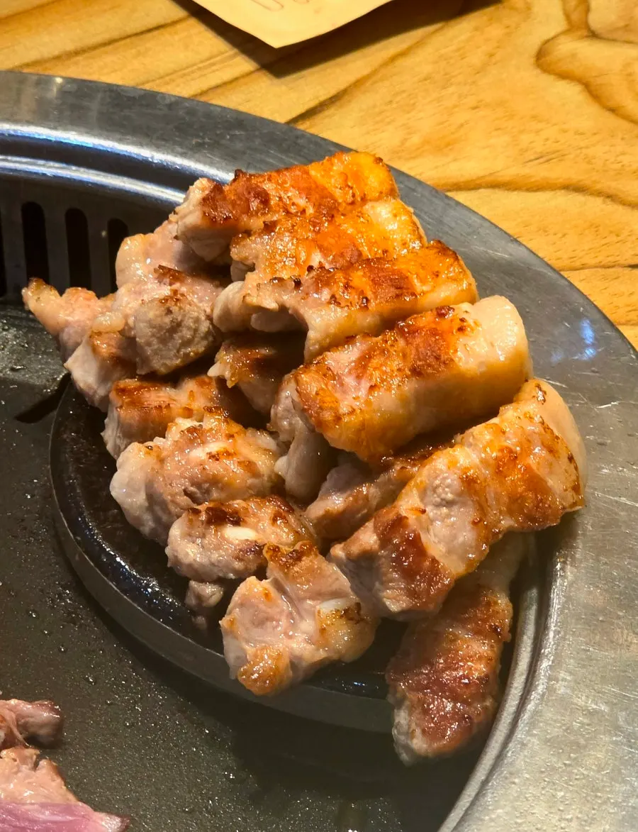 Pork belly and pork neck grilling on the hot plate