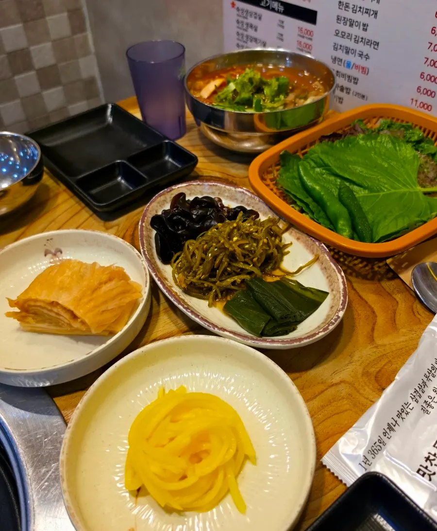 A spread of side dishes including baek-kimchi and mok-i mushrooms