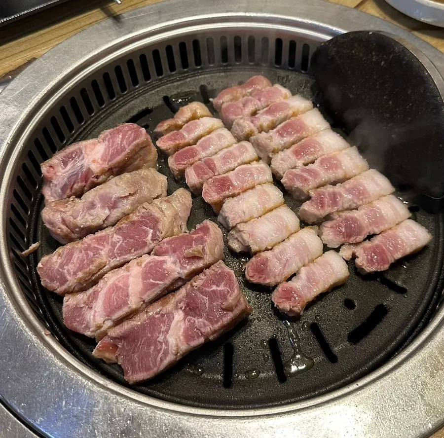 Staff grilling the meat on the tabletop grill