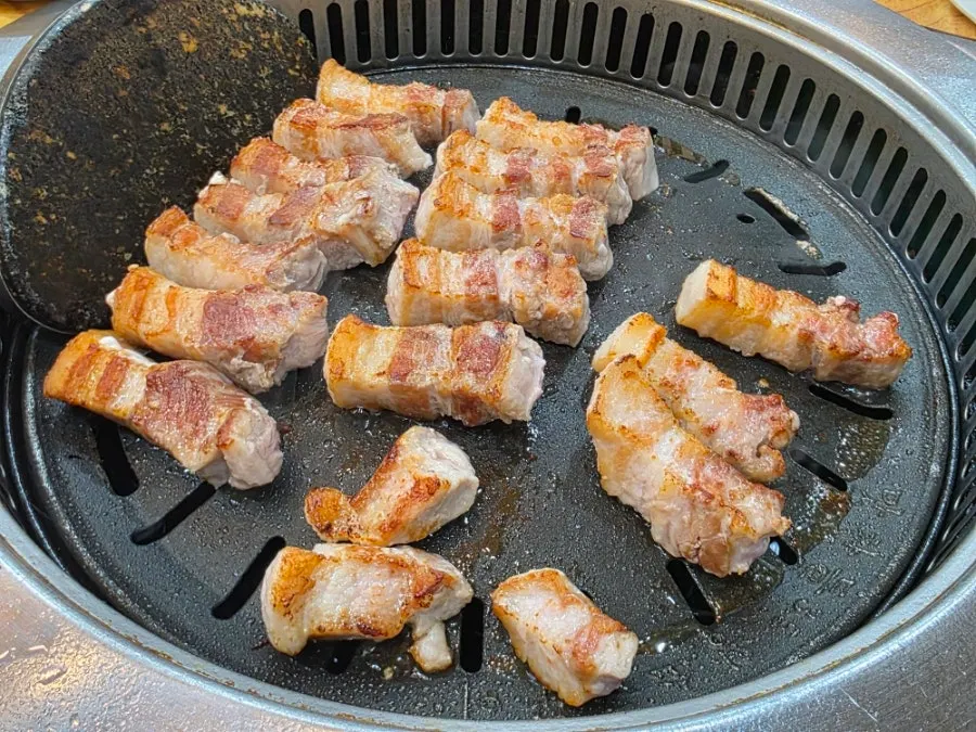 직원이 삼겹살을 뒤집는 모습