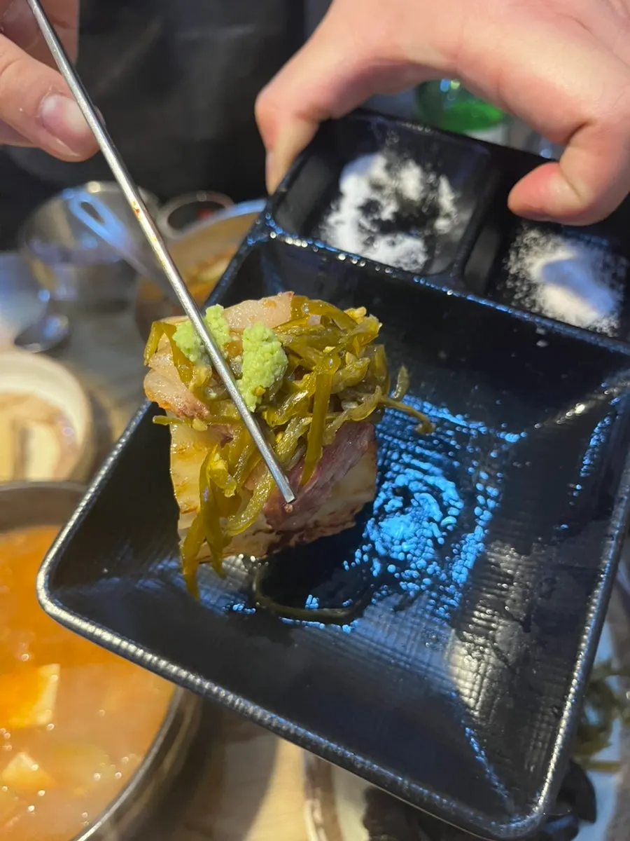 구운 백김치에 올린 삼겹살 한 점