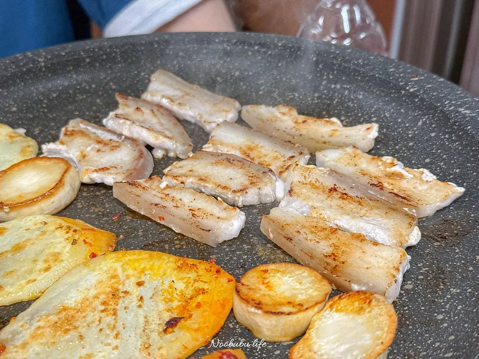 A piece of pork belly dipped in sauce