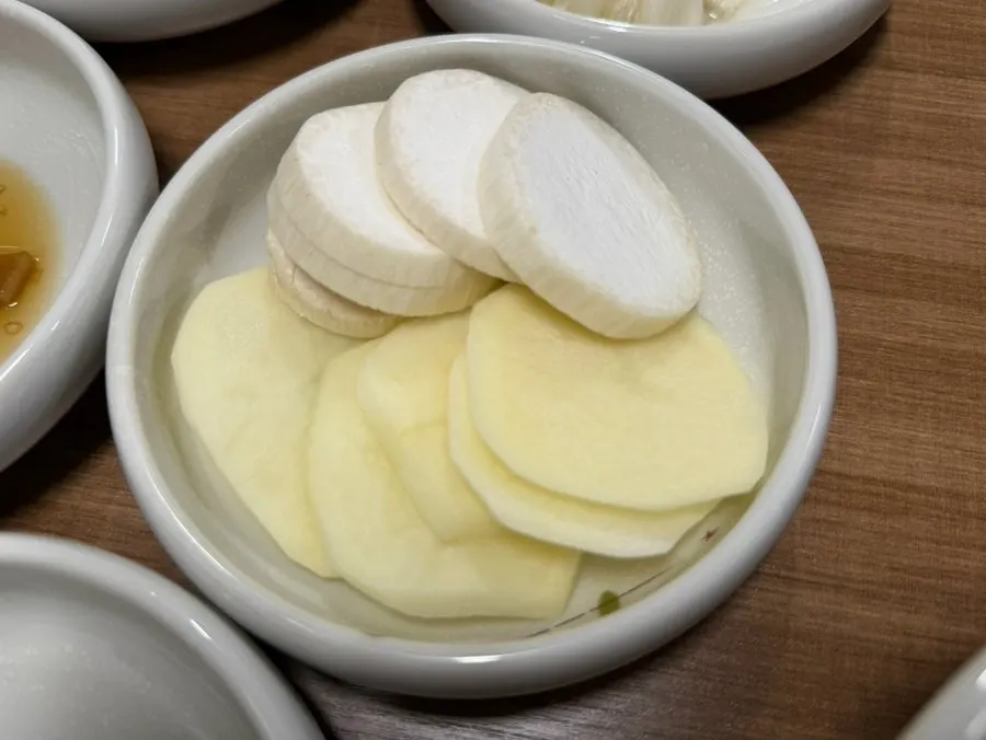 Mesa con banchan básicos y verduras para envolver