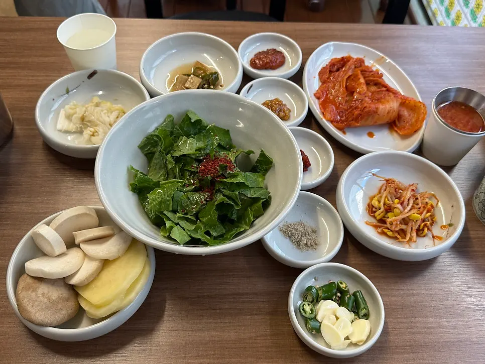 Mesa de banchan con lechuga en escabeche y kimchi asado, entre otros