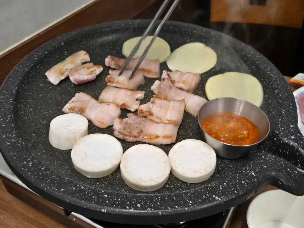 Garlic oil in a stainless bowl at the center of the grill