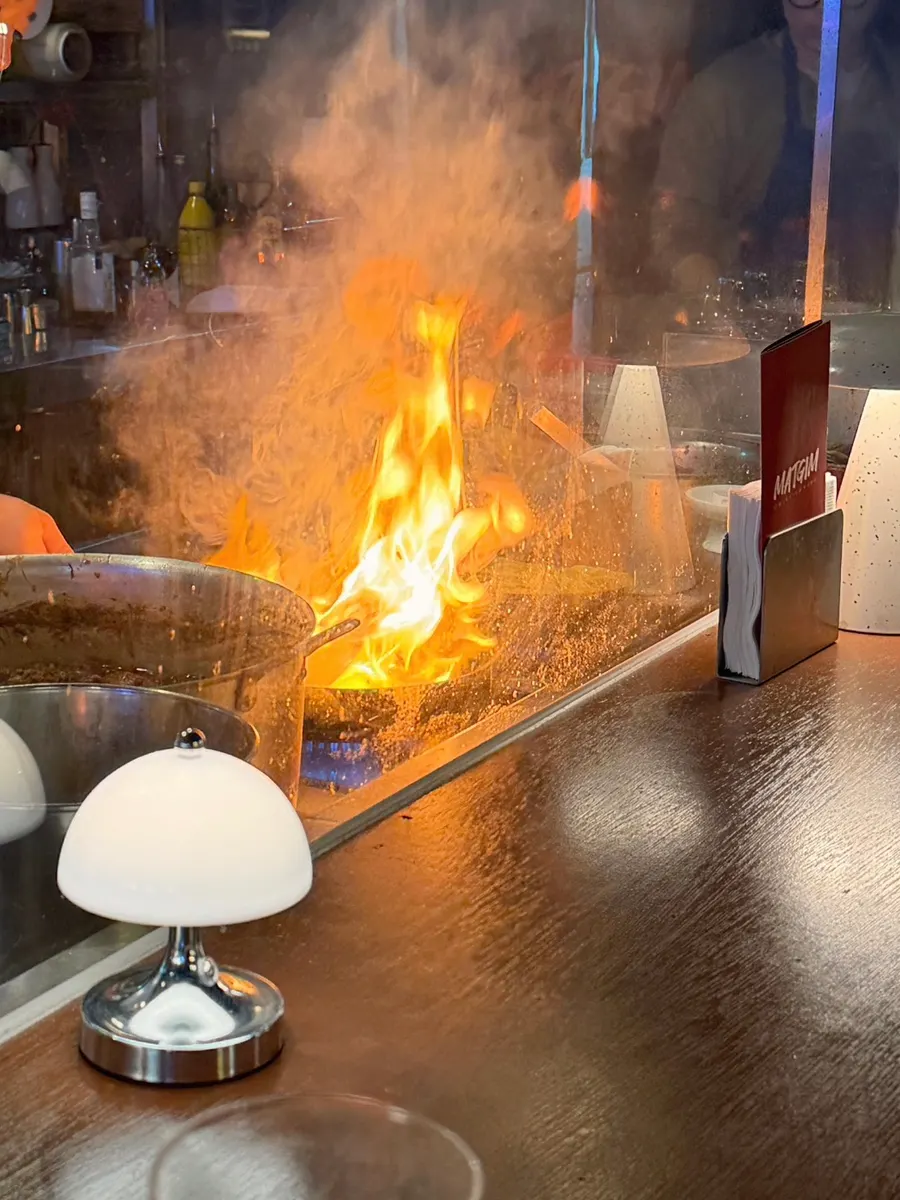 A fire show happening in the open kitchen