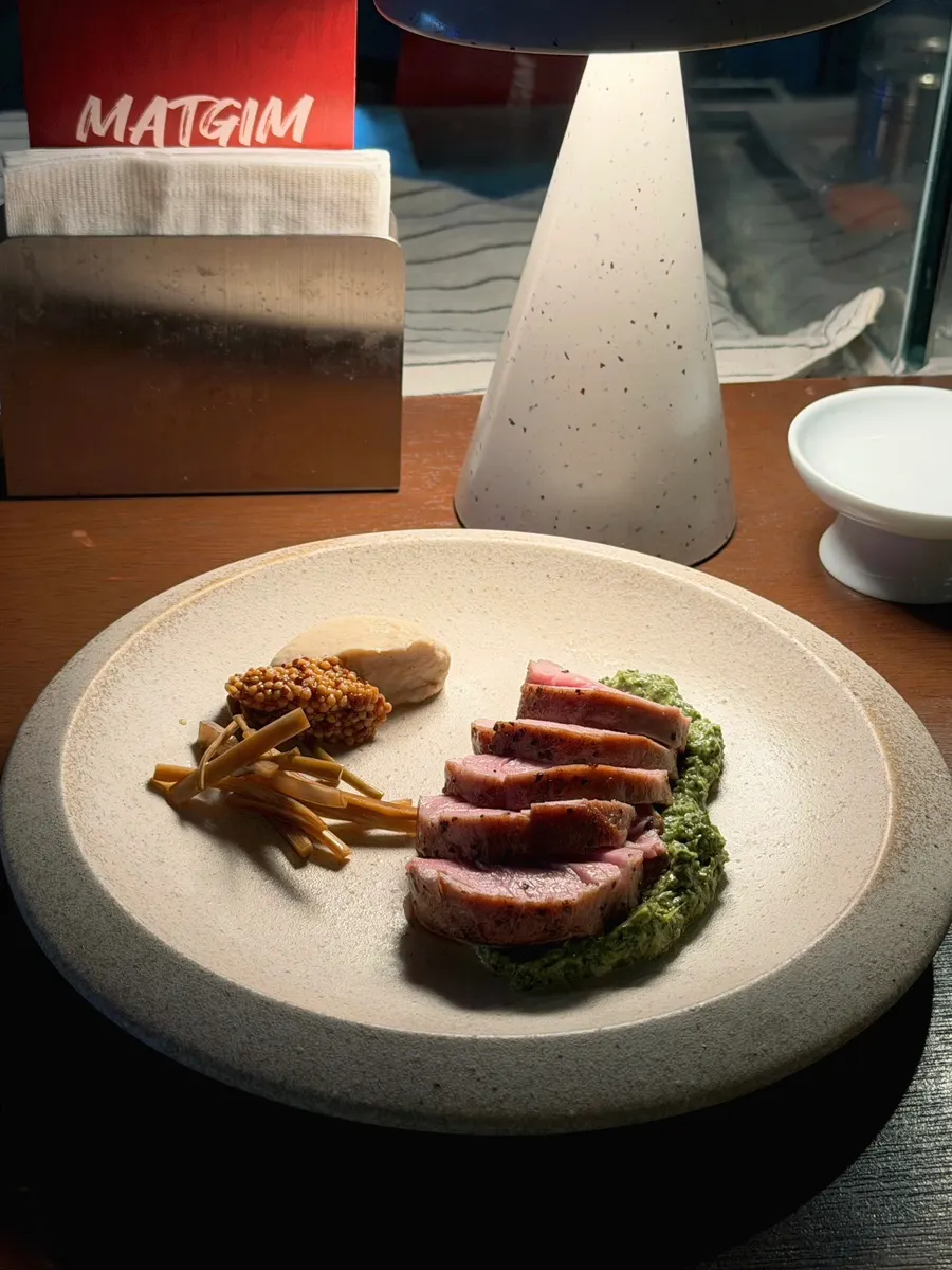 Pork tenderloin steak served with basil sauce and potato purée
