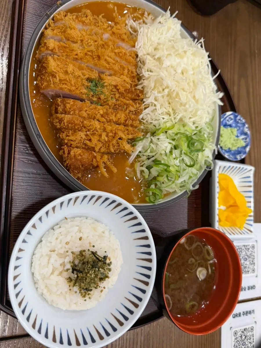 Miso katsu topped with white miso sauce and green onion