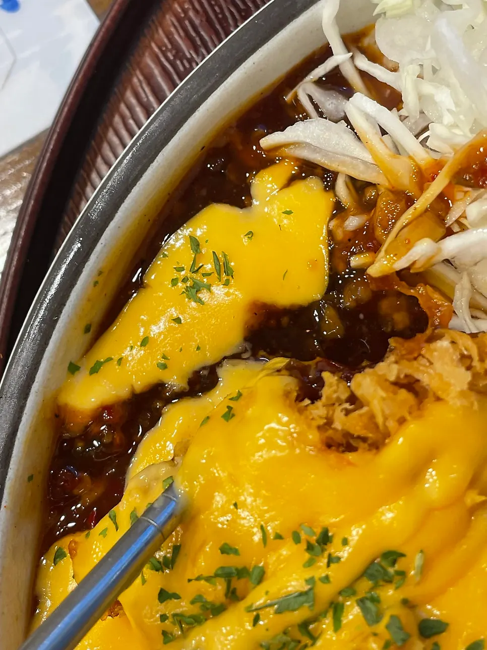 A piece of cheddar tonkatsu dipped in spicy sauce