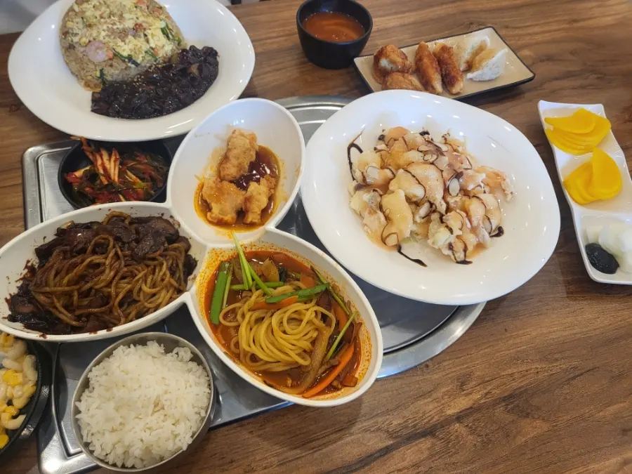 1인정식과 볶음밥 크림새우 모듬만두가 차려진 테이블