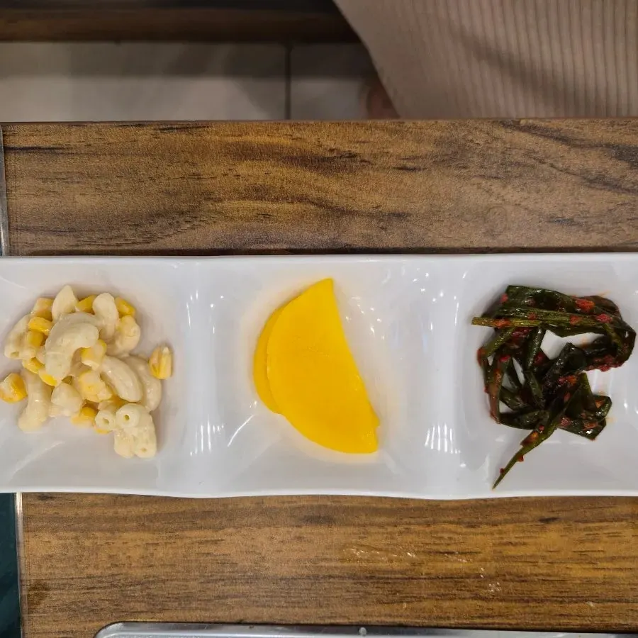 셀프바에서 담아온 파김치와 단무지 반찬 접시