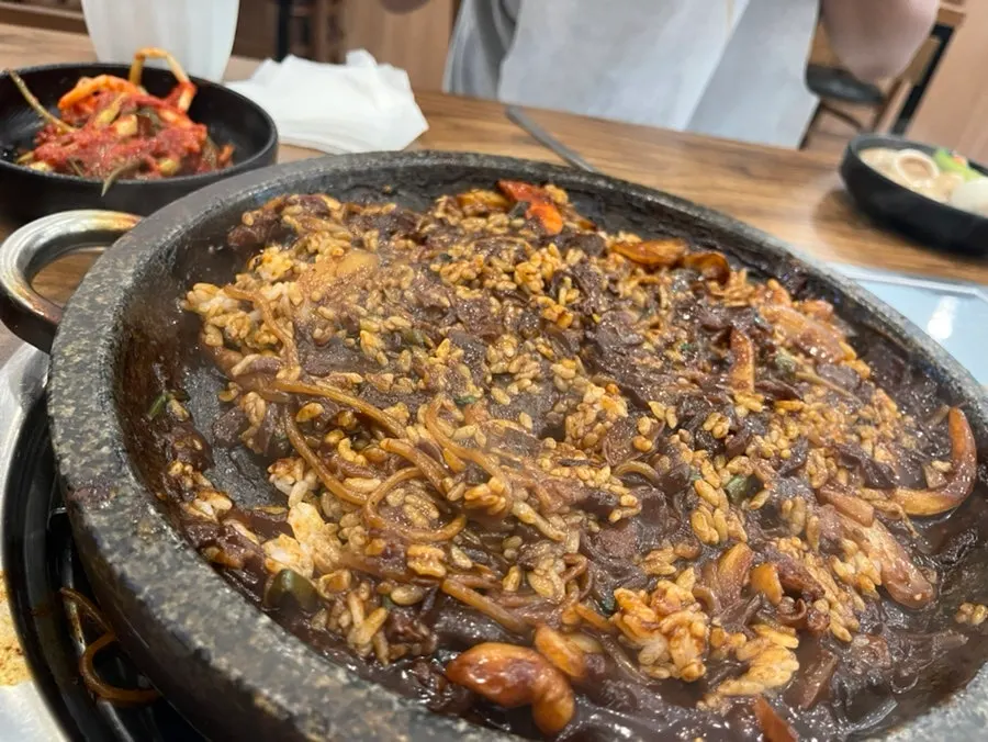 Staff mixing rice into the leftover jjajang sauce