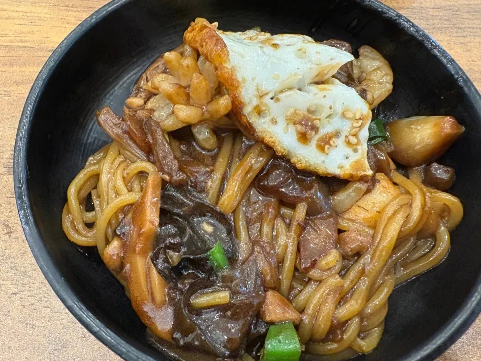 Close-up of stone jjajang topped with a fried egg