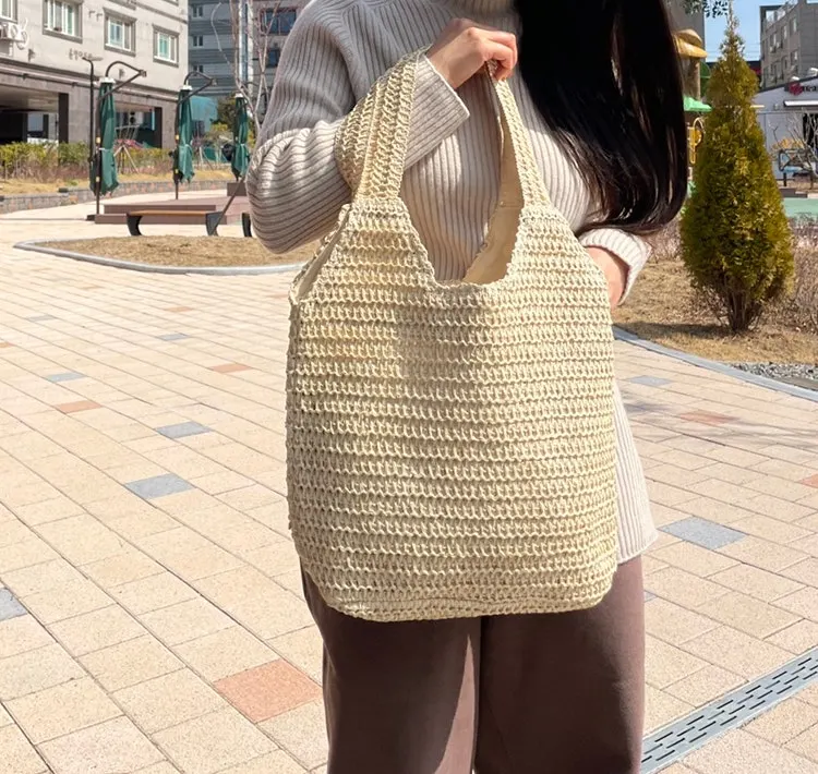 Wearing a beige rattan bag with a natural weave