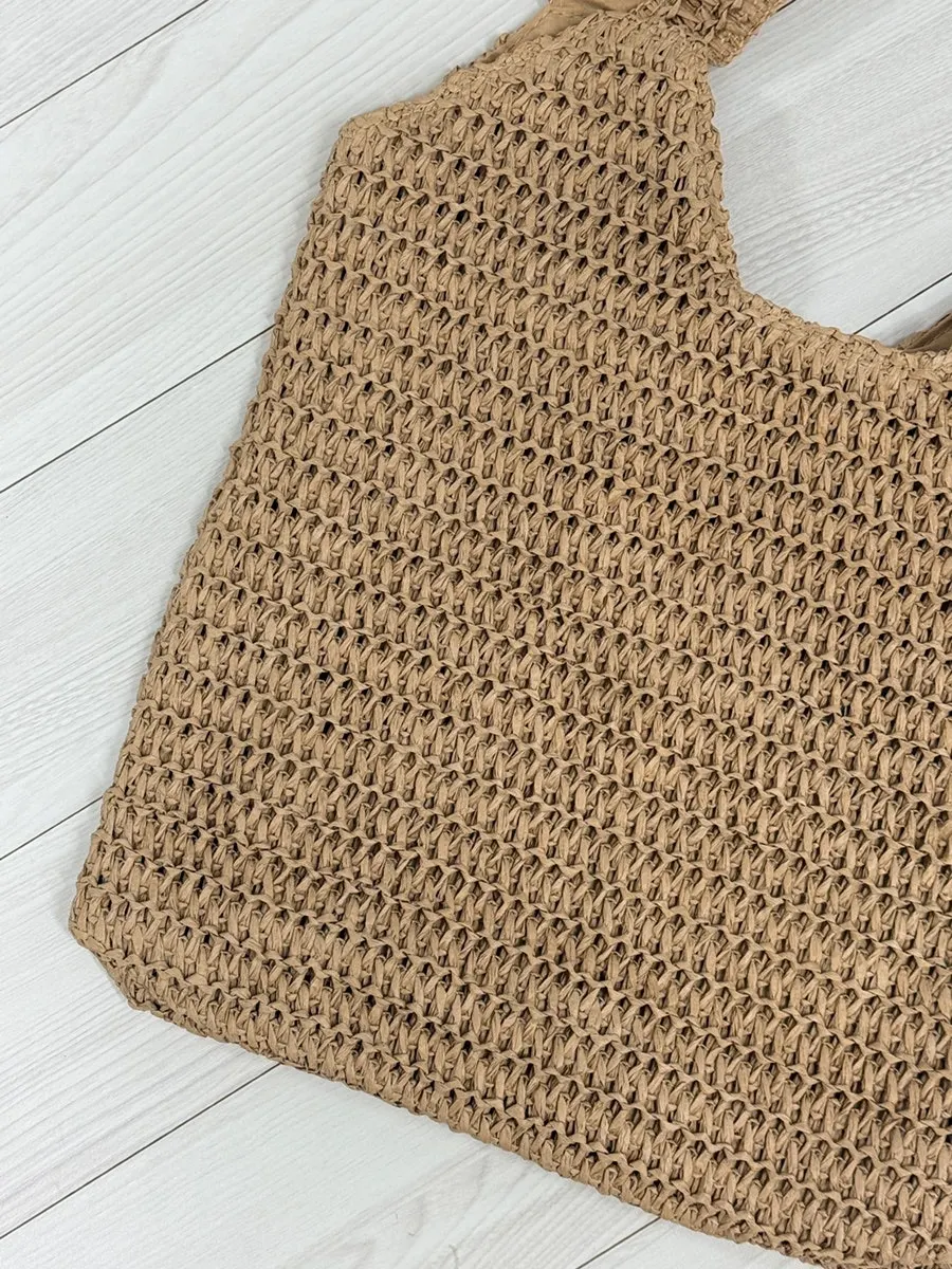 Examining the net weave of the Meda Bag rattan bag