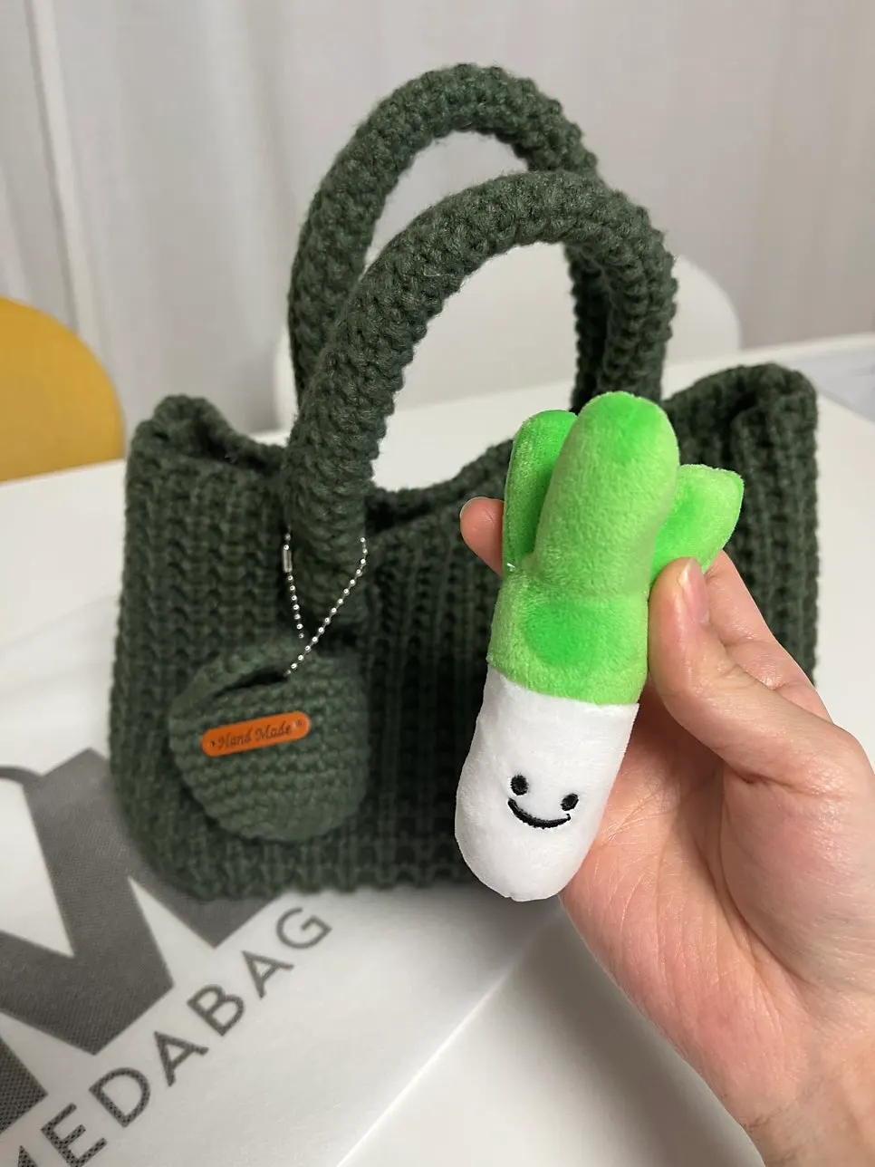 Shopping-bag keychain with a green onion keychain inside
