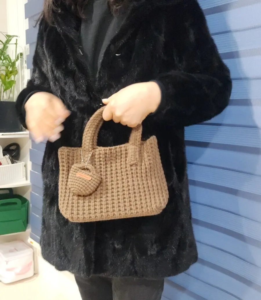 Knit tote bag held in hand