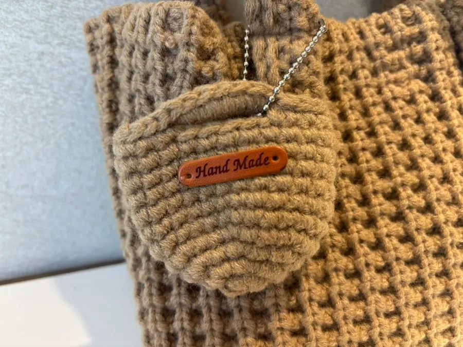 Beige knit tote bag and its front pocket