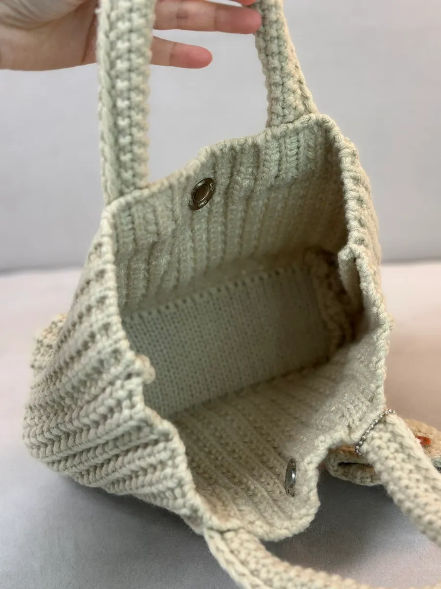 Knit bag handle and attached accessory