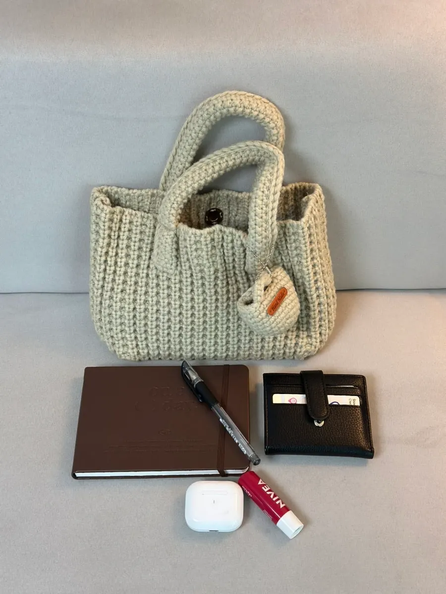 Side view of the beige knit bag