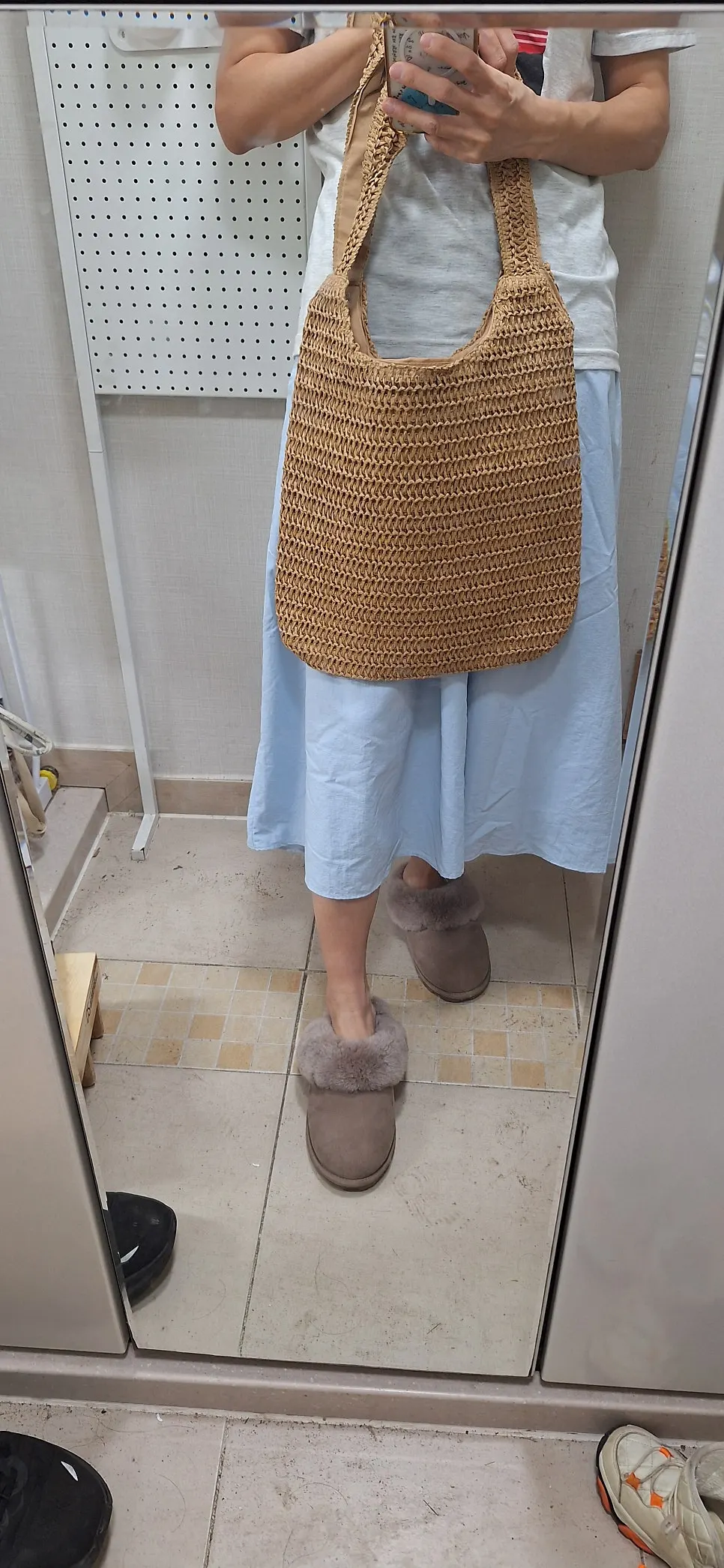 Rattan shoulder bag falling beside the waist and hips