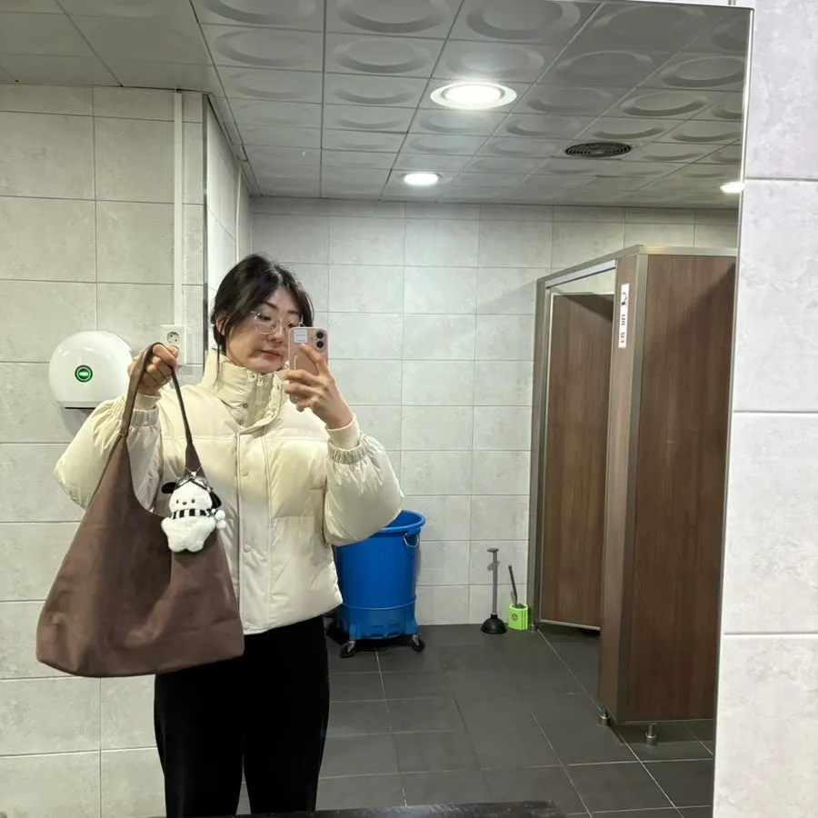 Wearing the suede bag in a bathroom photo