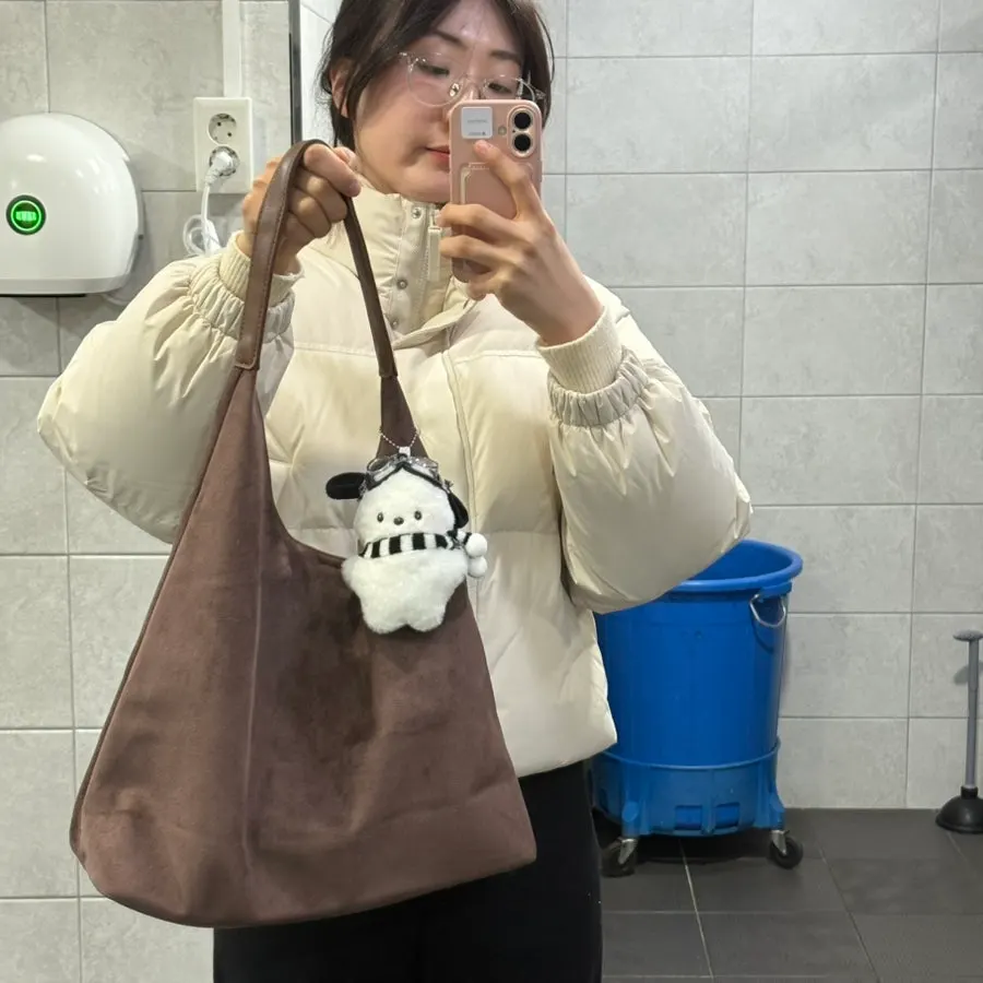 Wearing a generously sized suede shoulder bag