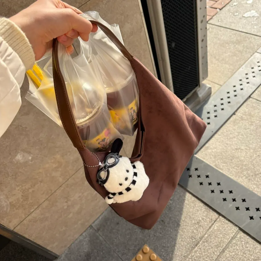 A suede shoulder bag carried on a casual outing