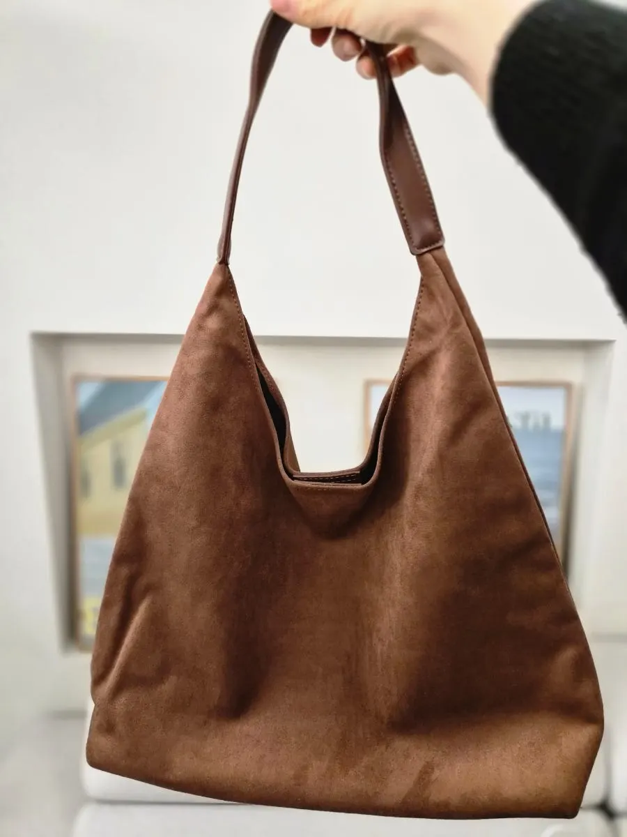 카멜 색상 메다백 숄더백을 어깨에 멘 모습