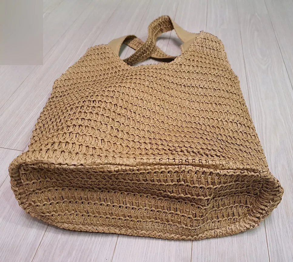Brown rattan shoulder bag with a curved shape