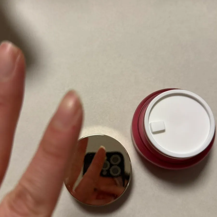 Cream container protected by a plastic inner cover
