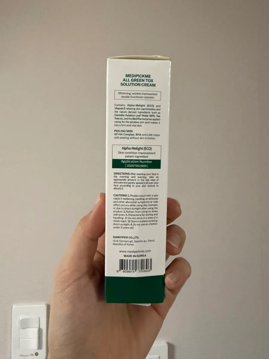 All Green Tox Solution Cream package held in a hand