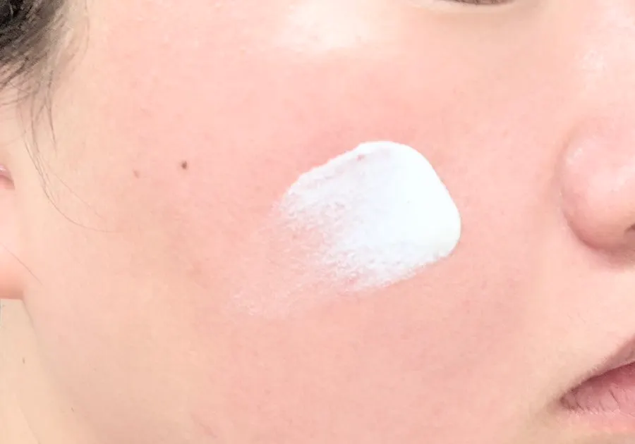 Lotion-texture sunscreen spread on the back of a hand