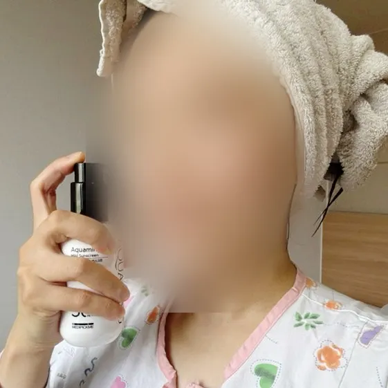 얼굴에 선크림을 펴 바르는 모습