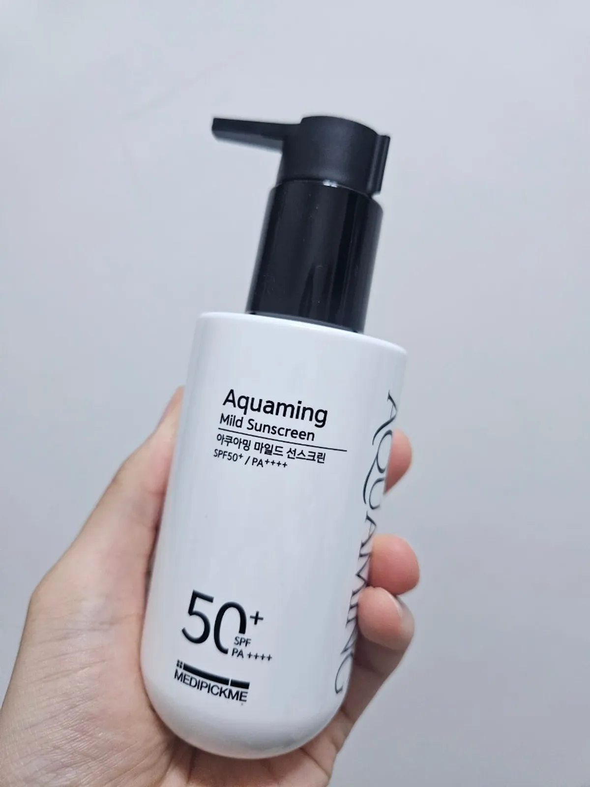 Holding the 150ml low-irritation sunscreen in hand