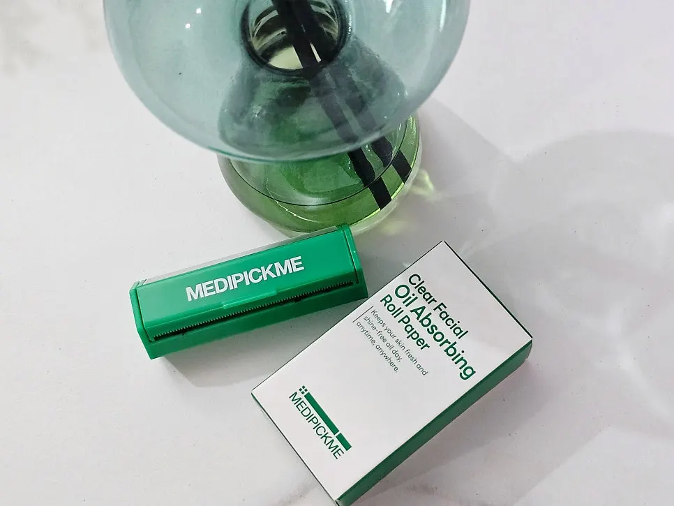 Oil blotting paper case with a refill roll inserted