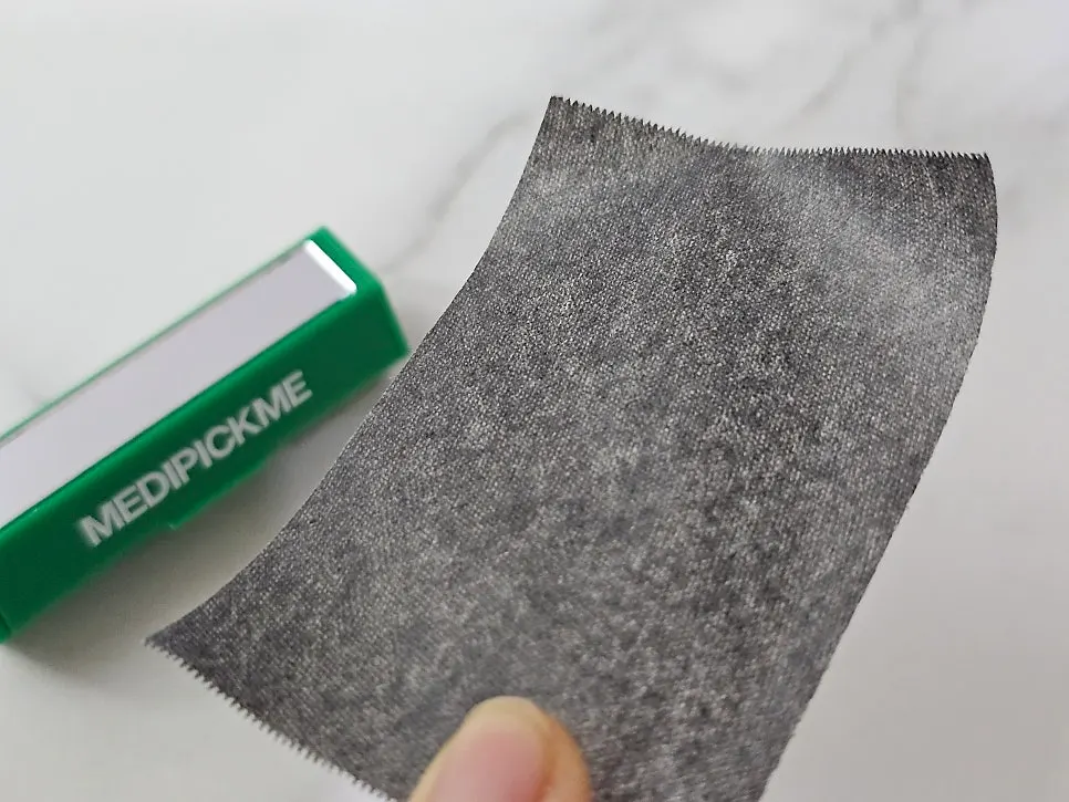 Oil blotting paper clearing oil from the forehead