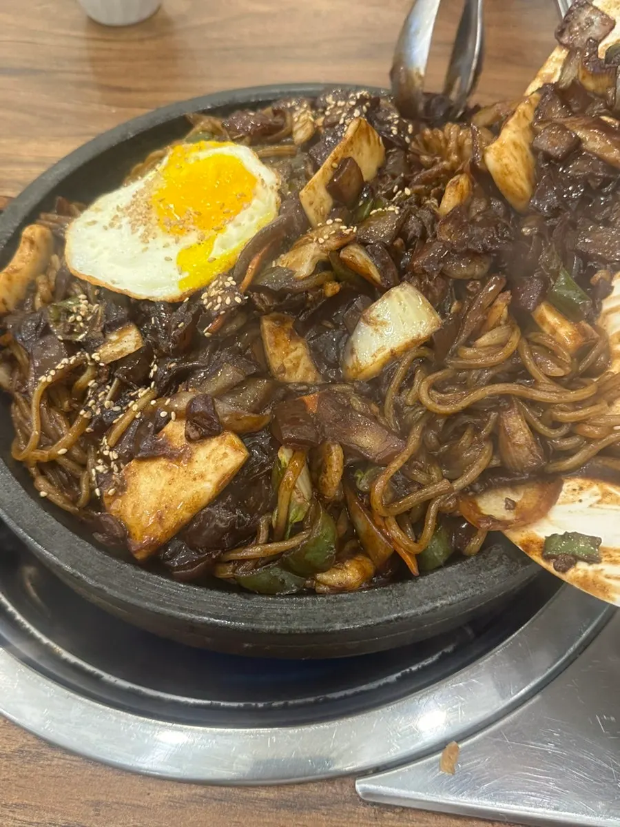 Mayway's stone-griddle jjajang with black bean sauce poured on top