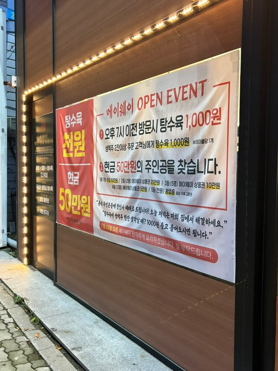 Mayway's glass storefront entrance with grand opening notice