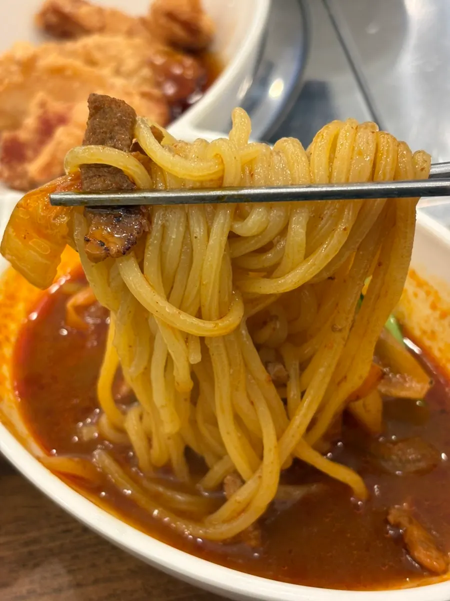 Close-up of jjamppong noodles and broth with toppings