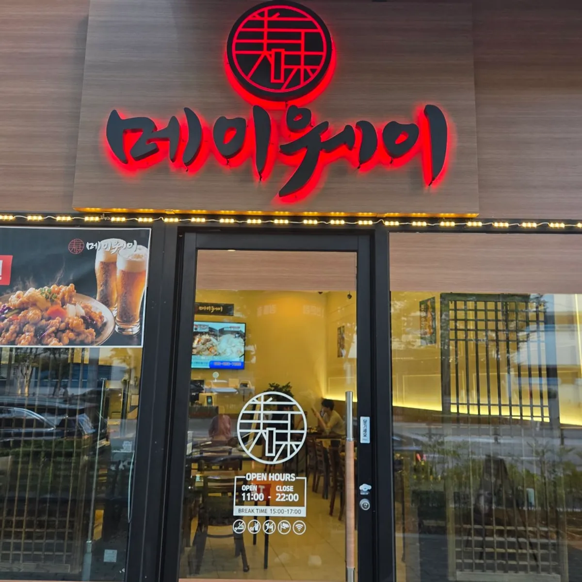 Mayway entrance with a red circular logo sign and posted business hours