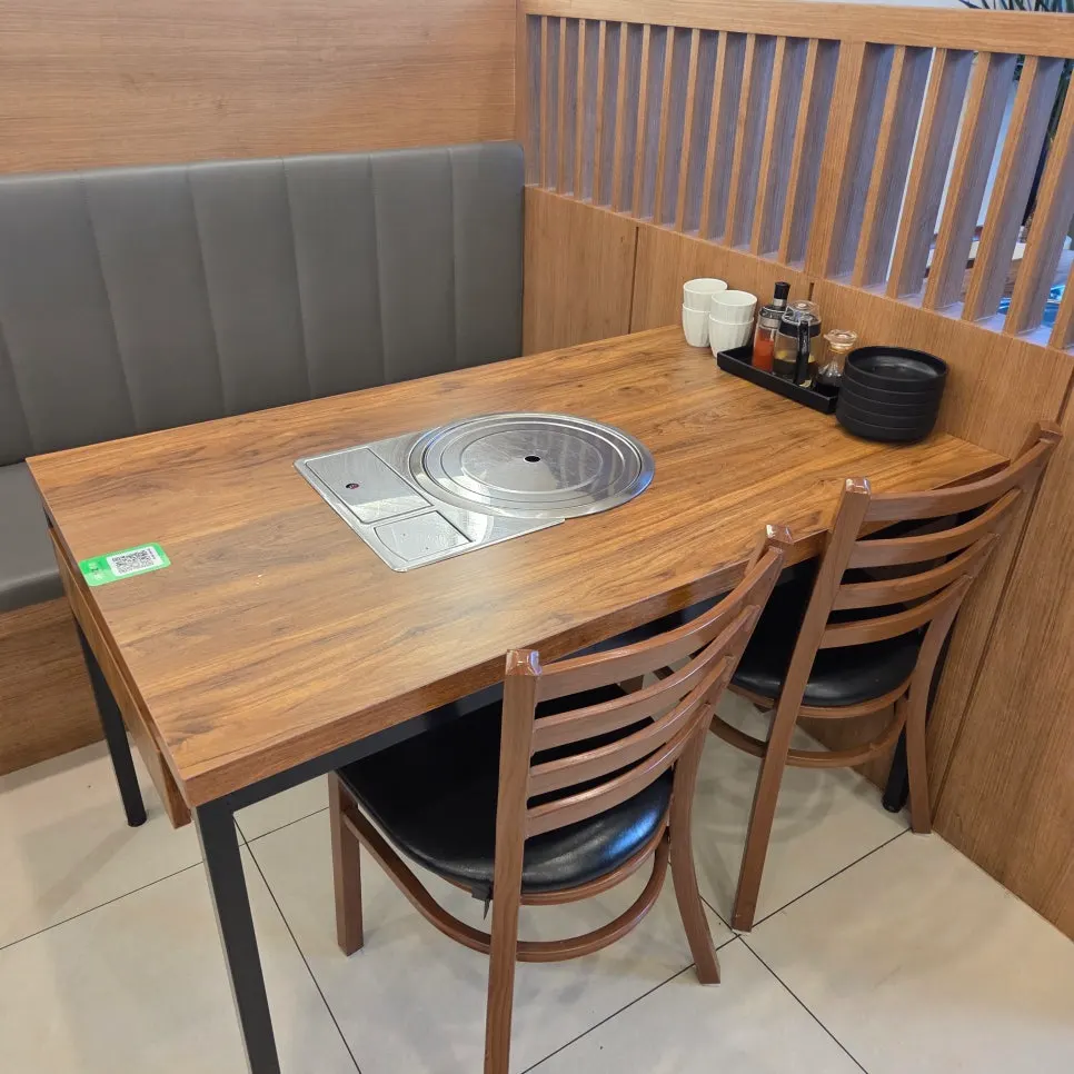 Interior with tables featuring built-in burners and bench seating