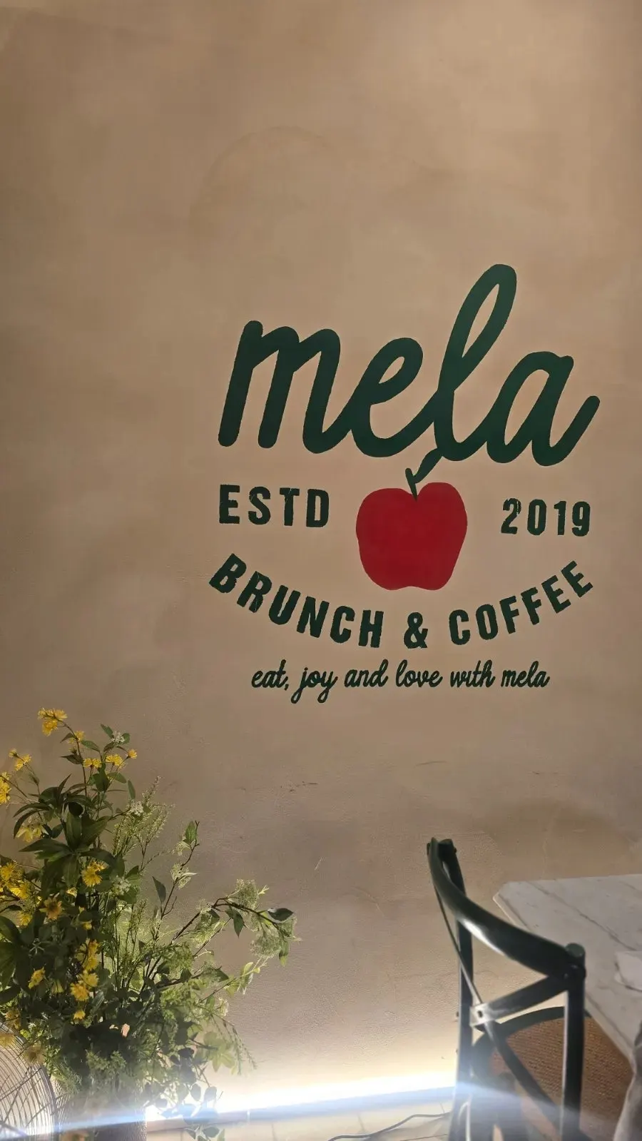 mela sign with a red apple illustration