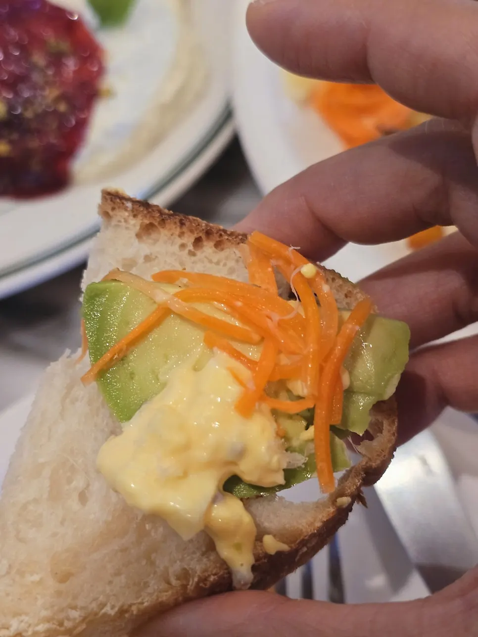Avocado, carrot rapée, and egg salad piled on bread