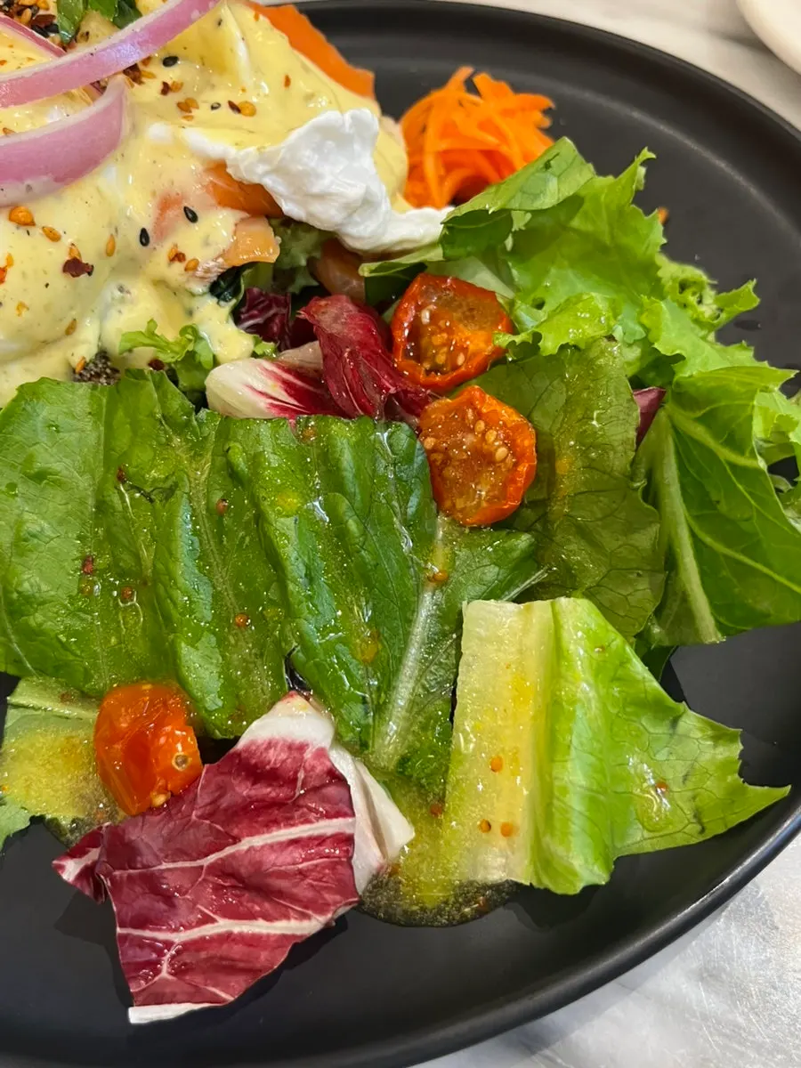 Vegetable salad served with the salmon eggs Benedict