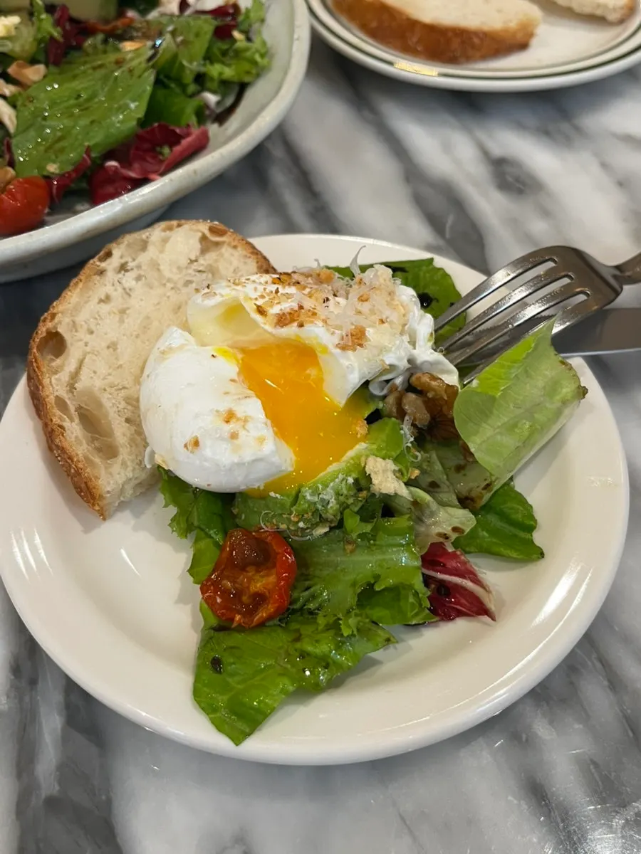 A slice of bread topped with avocado and poached egg