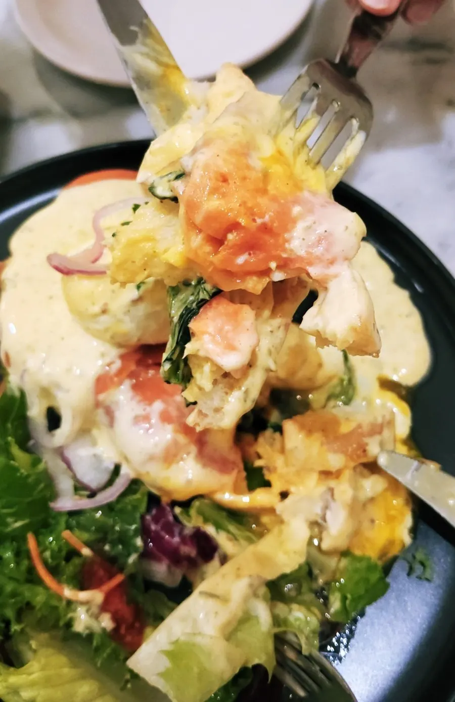 Salmon eggs Benedict with broken poached egg and fermented bread