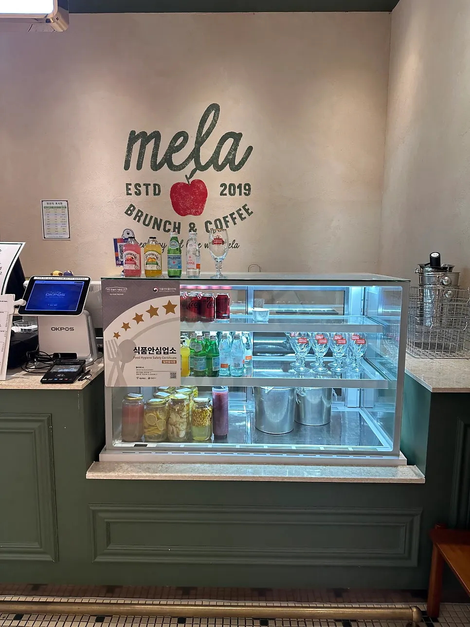 Menu board listing Mela's coffee and drink options