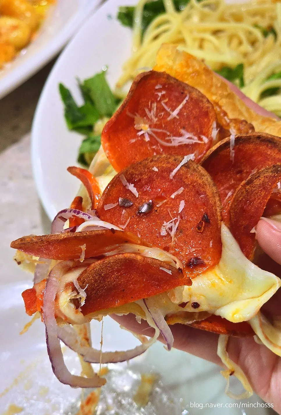 A slice of pepperoni pastry pizza lifted up