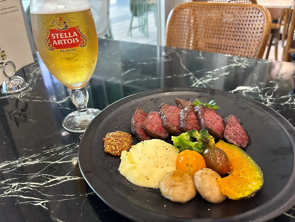 Full spread of steak, pasta, and salad at Mela